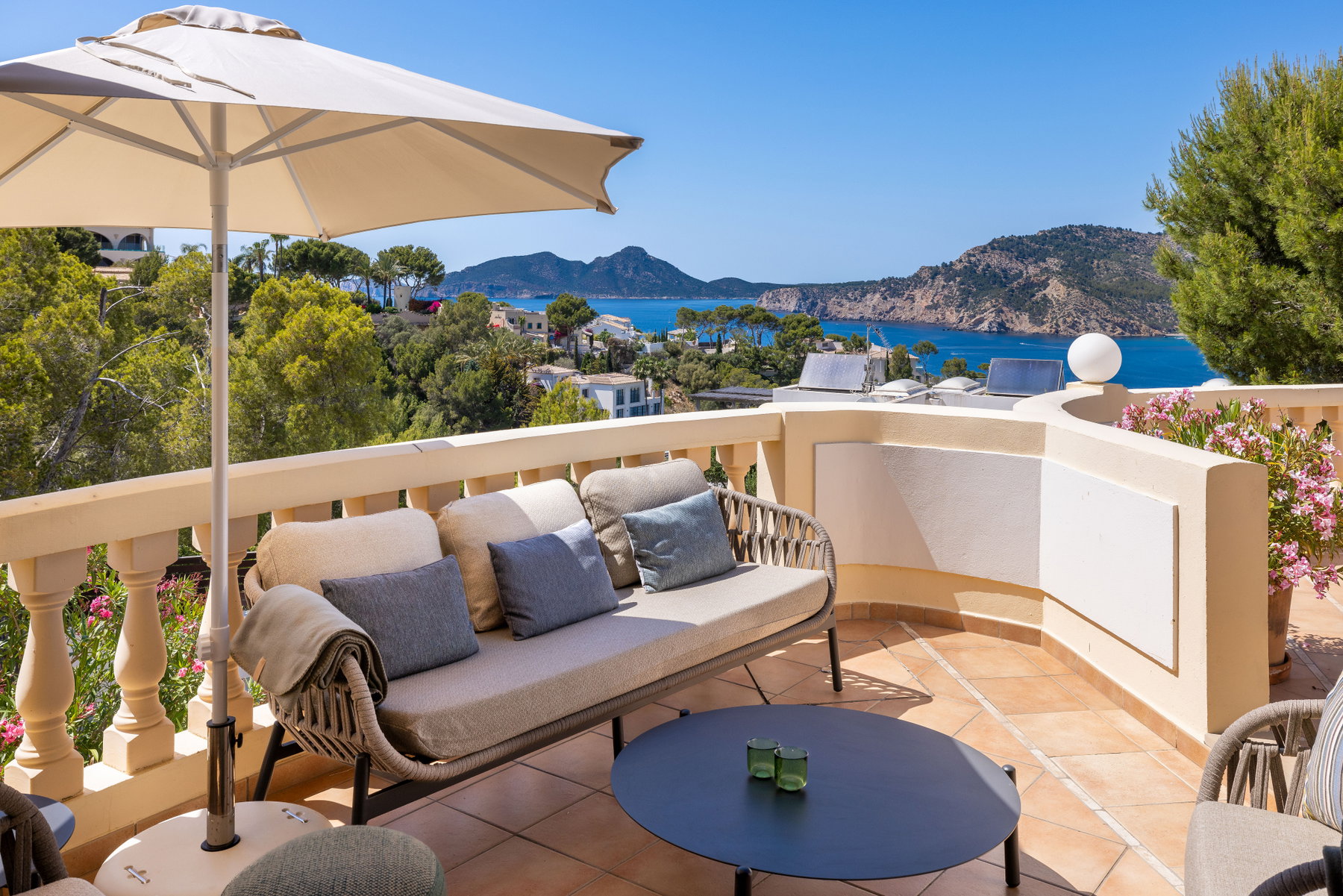 Loungeområde på terrassen med parasol og havudsigt