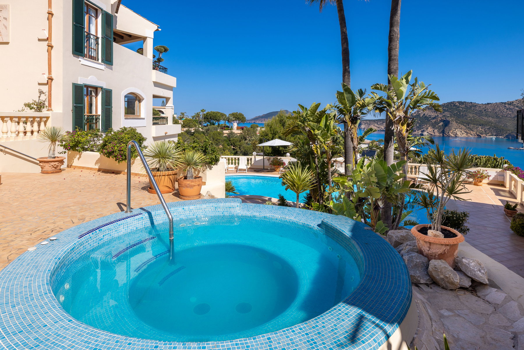 Poolterrasse med palmer og udsigt til Middelhavet